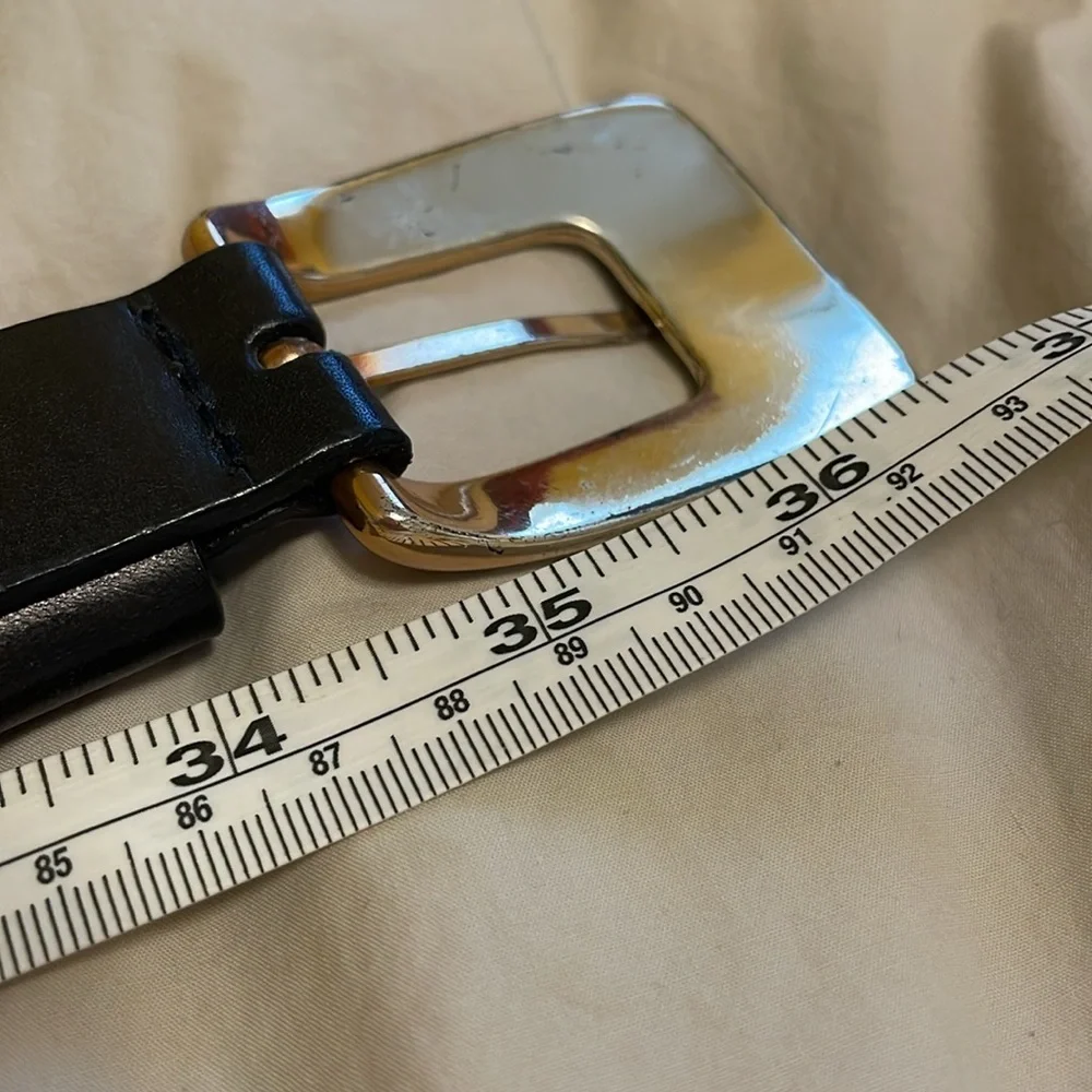 Genuine leather belt from Kenneth Cole. Metal buckle. Measures about 35 inches.